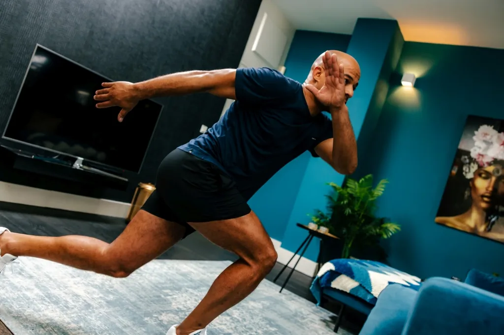 A phone on a tripod filming a workout in the living room