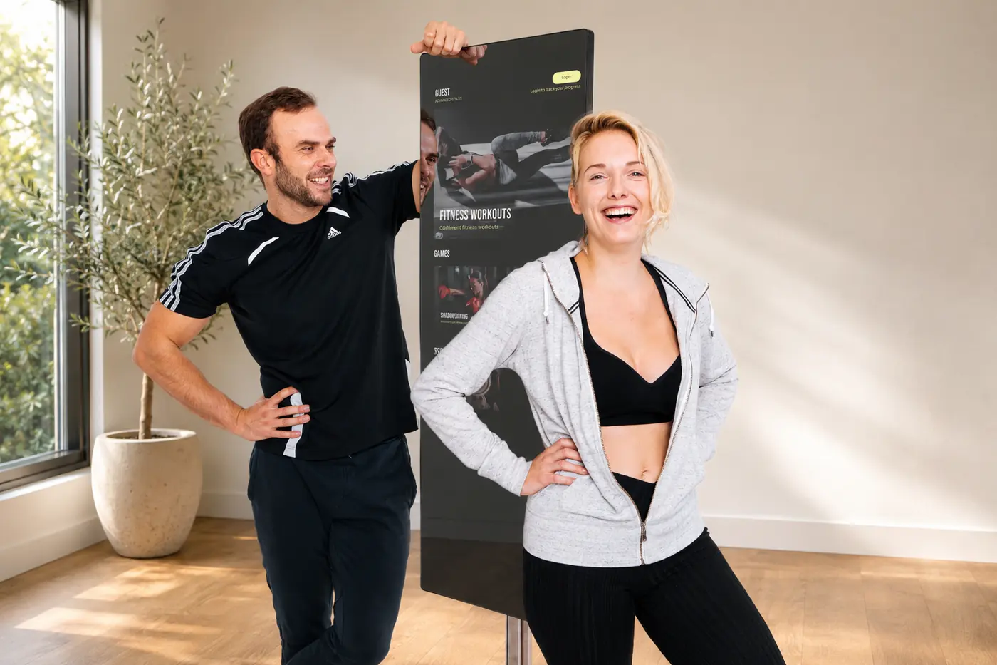 Compact Mirror met workout-menu op het scherm, tussen twee sporters